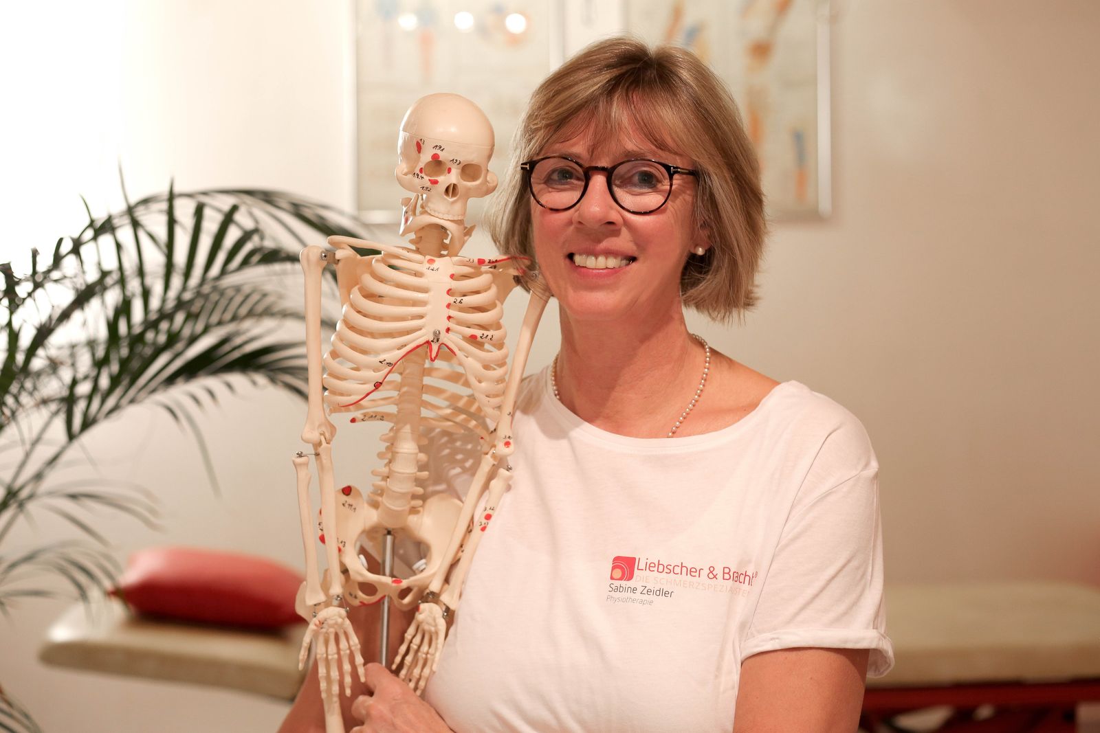 Sabine Zeidler mit Anatomiemodell in ihrer Praxis